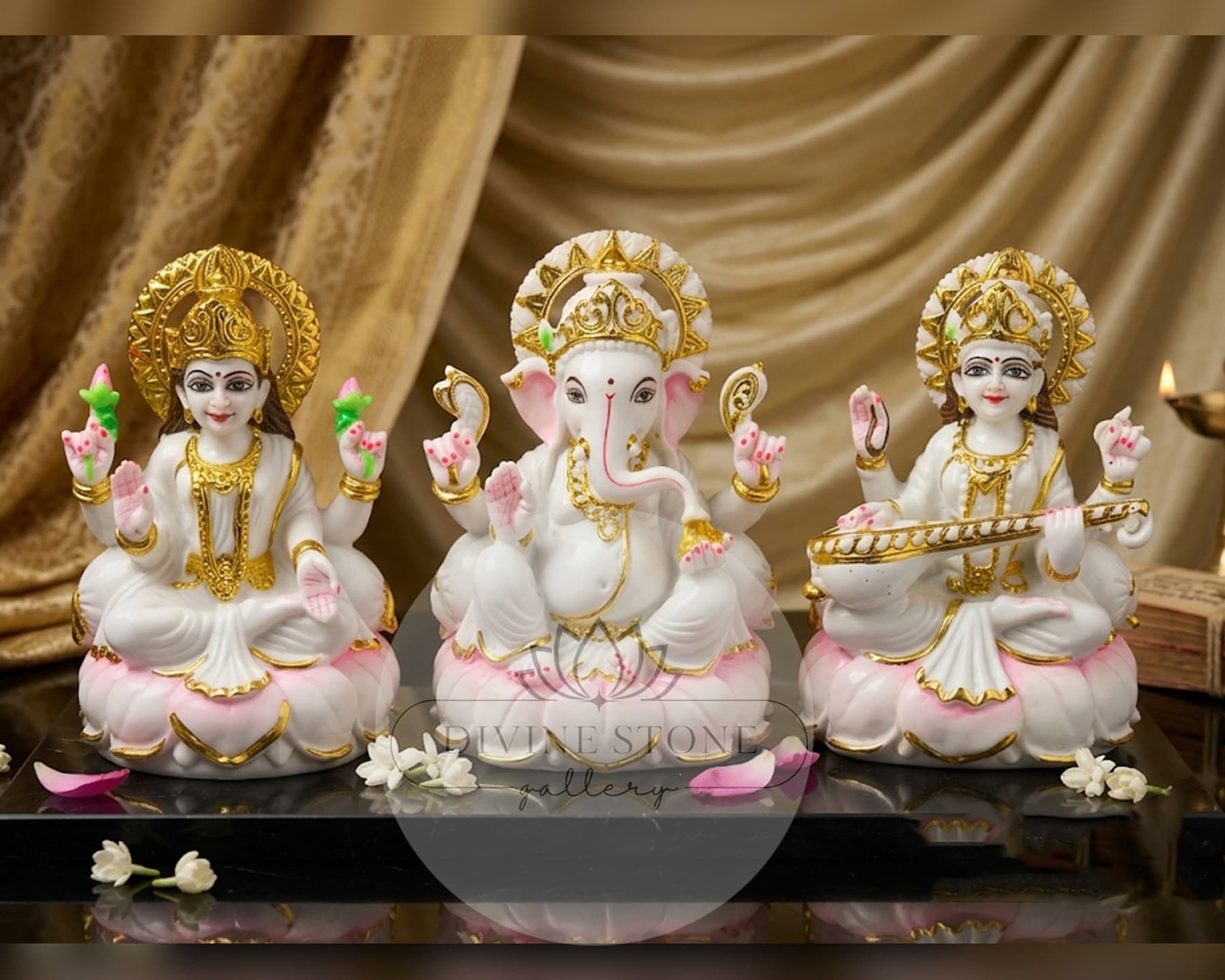 Lakshmi, Ganesha and Saraswati marble moorties arranged in a devotional setting